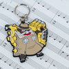 Skullgirls Big Band keychain proudly displayed on a sheet of music.